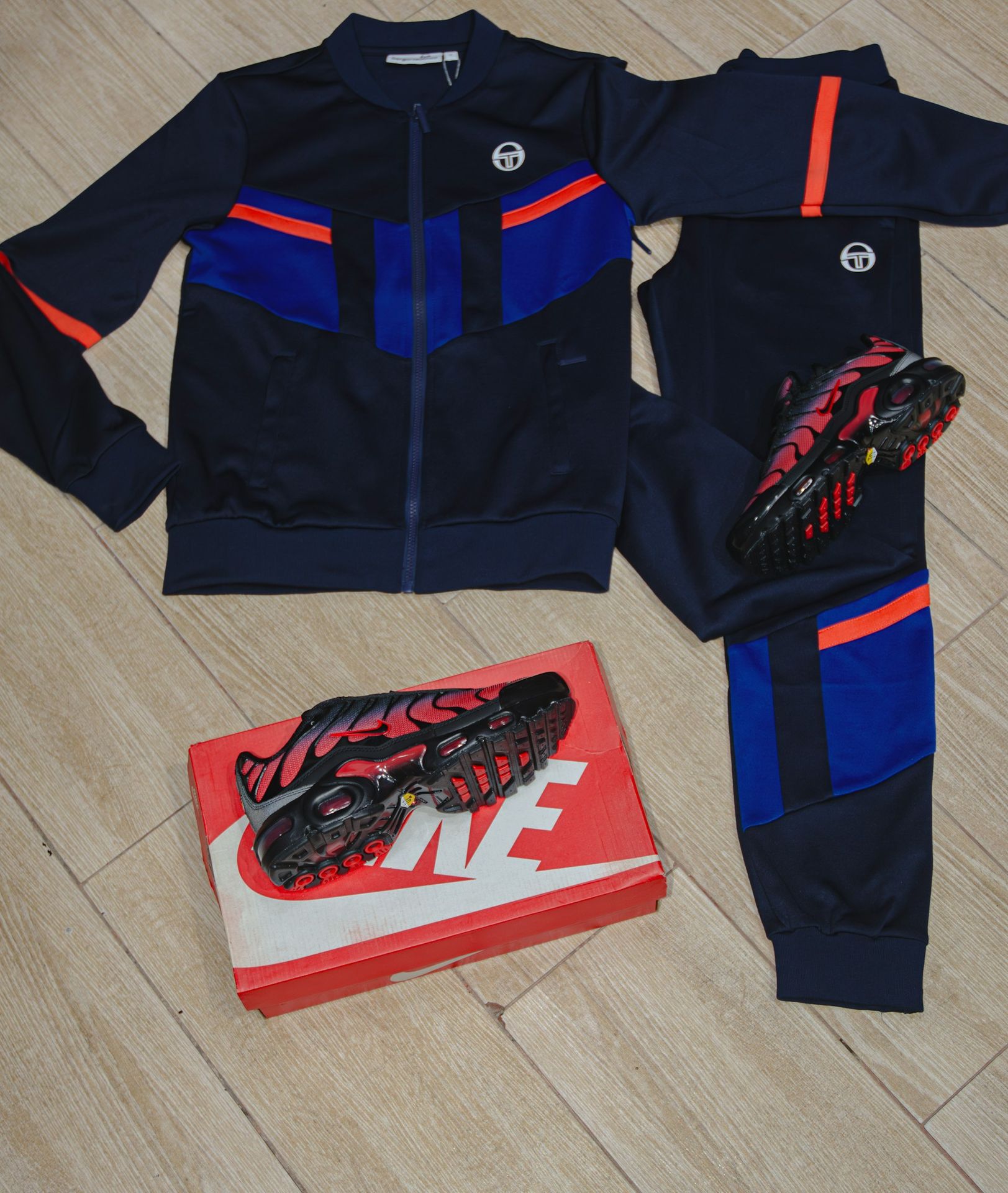 a pair of shoes and a pair of running shoes sit on the floor next to